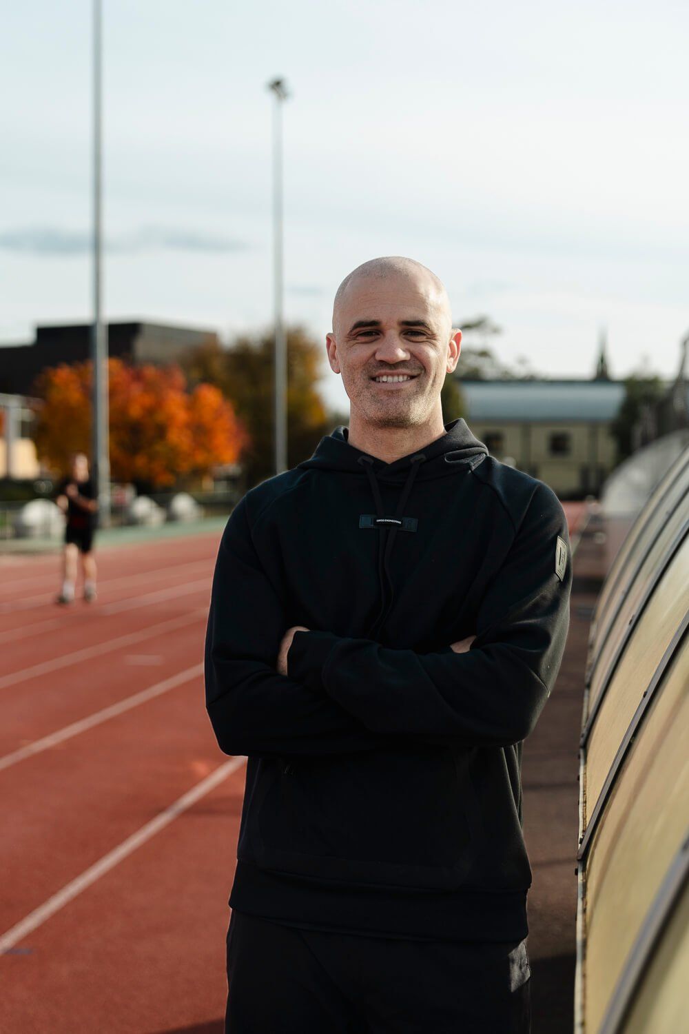 Dan Bryant smiling beside a running track